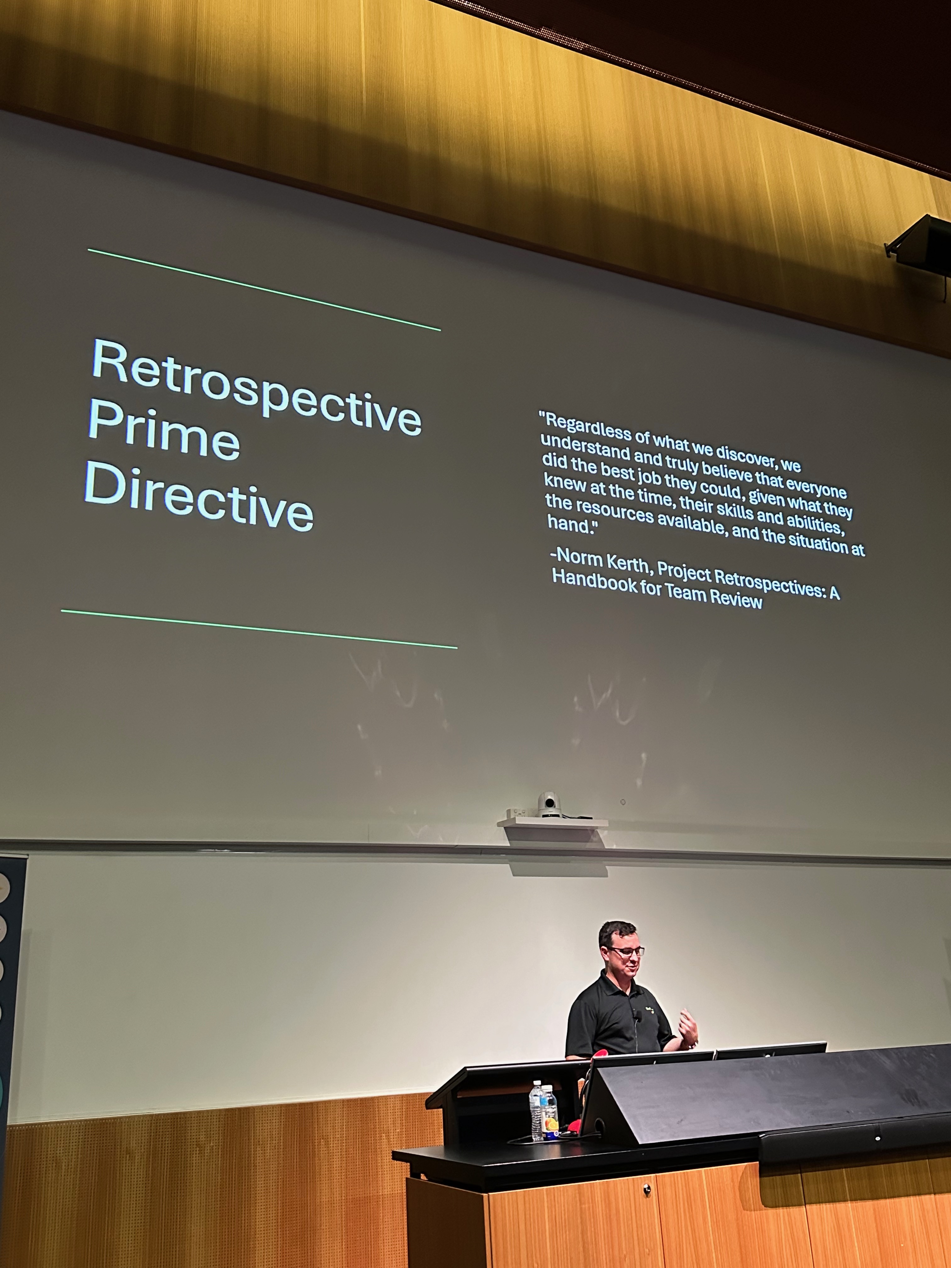 Chris standing in front of a presentation slide featuring the Retrospective Prime Directive.